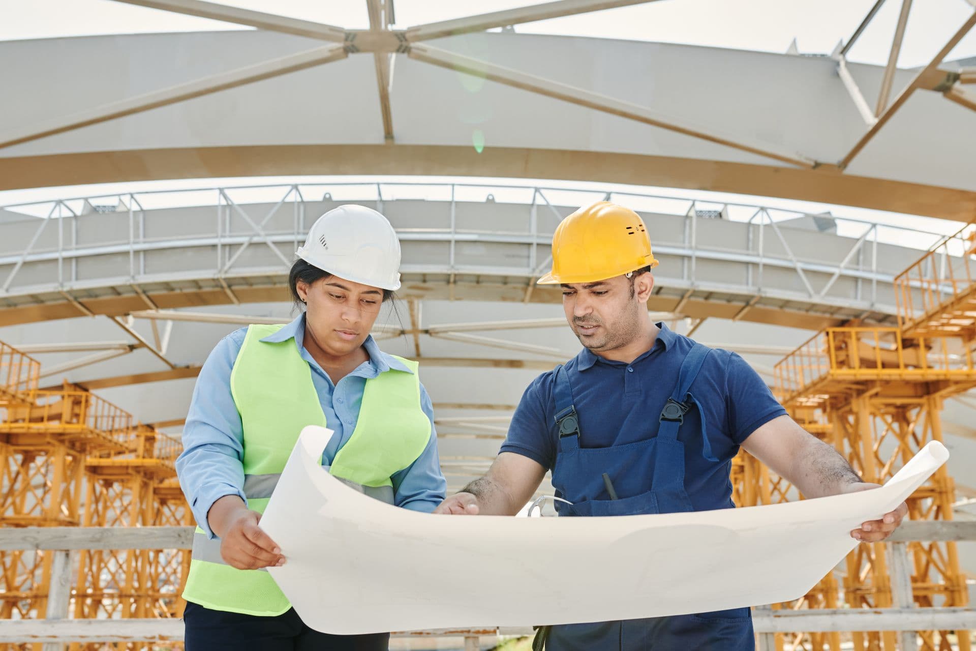 Two workers reviewing a construction drawing on site